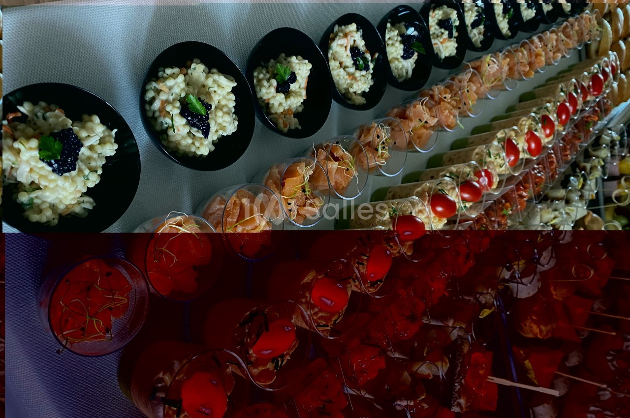 Buffet avec rangées de verrines et assiettes contenant des plats variés, dont du risotto et des garnitures colorées.
