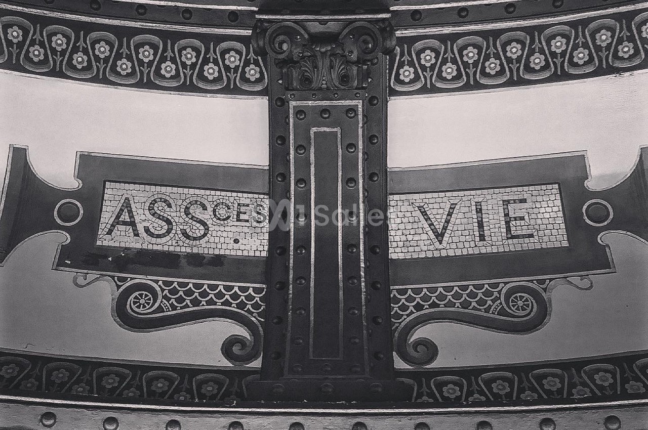 Motif décoratif en mosaïque avec les mots ’ASSURANCE VIE’ sur une structure métallique ornée.