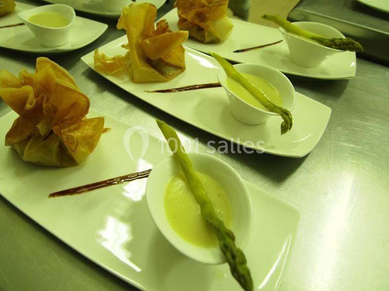Assiettes dressées avec des croustillants, des asperges et une sauce servie dans des coupelles blanches.