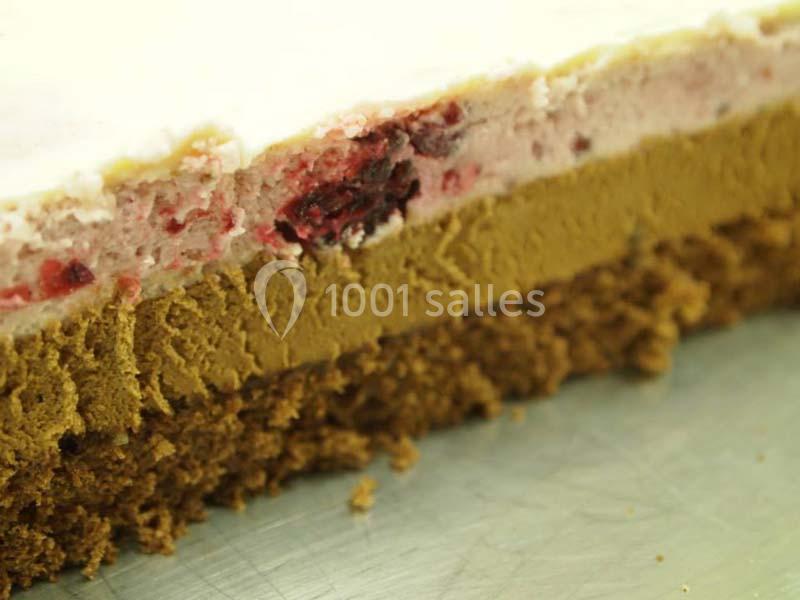 Coupe d'un gâteau en couches avec biscuit, mousse au chocolat et crème aux fruits rouges.