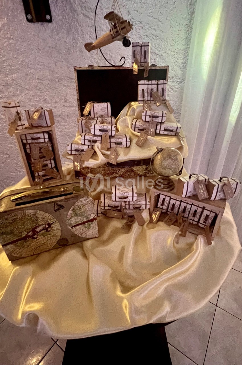 Présentoir décoratif avec des boîtes cadeaux ornées de rubans, disposées sur un tissu doré dans un cadre intérieur.