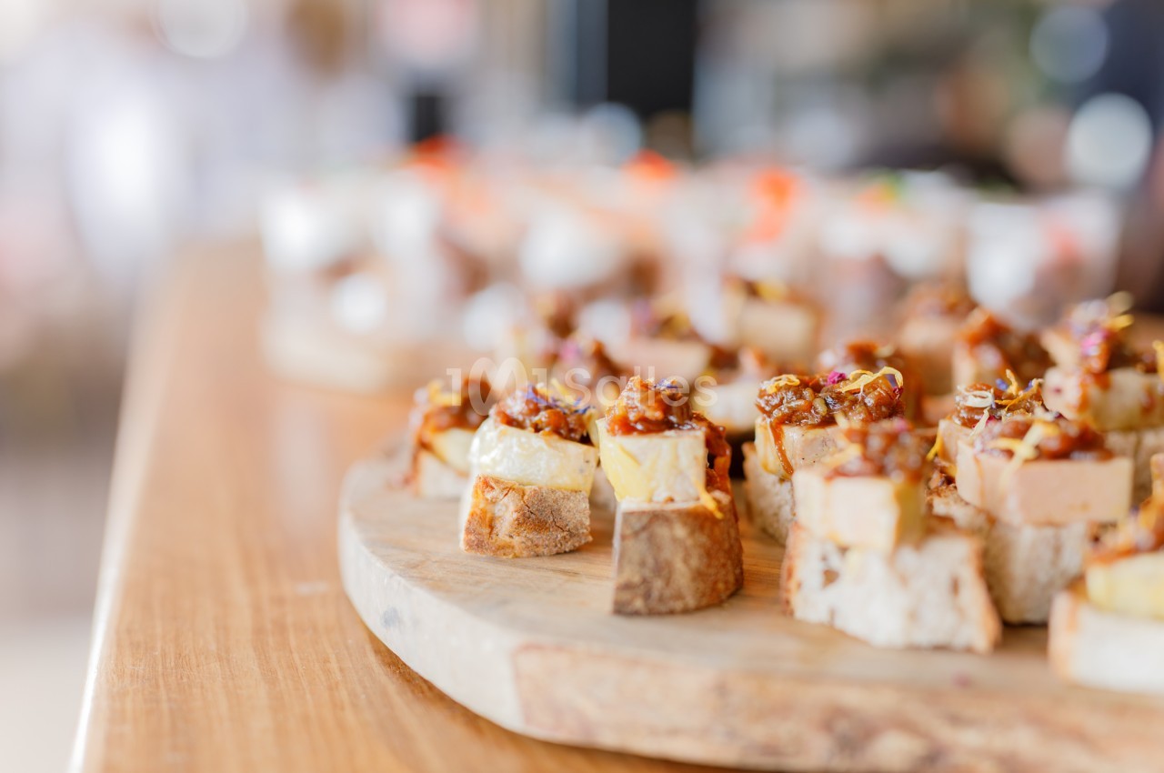 Canapés garnis de fromage et de copeaux de noix sur planches en bois.