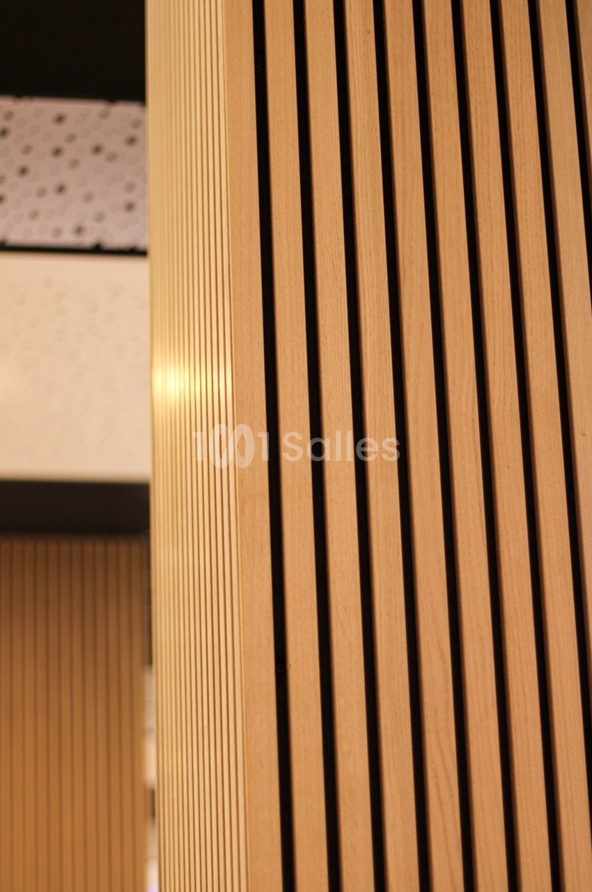 Panneaux en bois clair avec des rainures verticales, intégrés dans un espace intérieur moderne.
