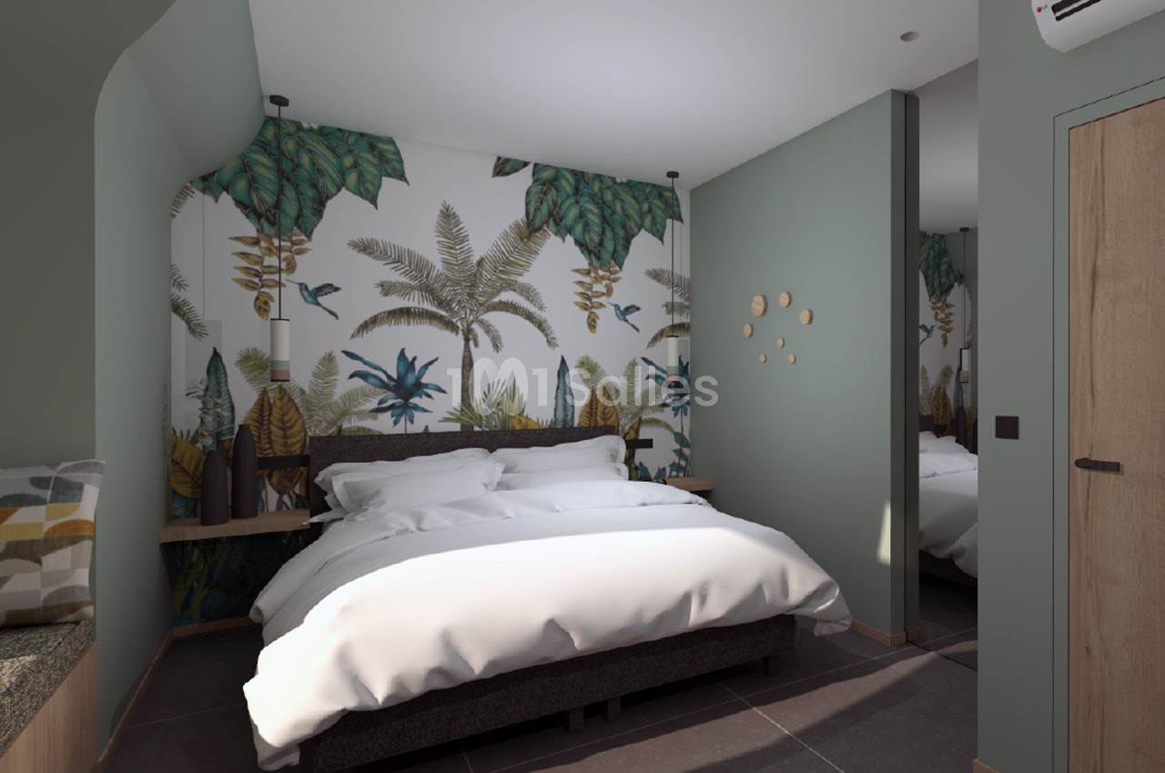 Chambre avec lit double, mur décoré de motifs tropicaux, éclairage doux et mobilier moderne.