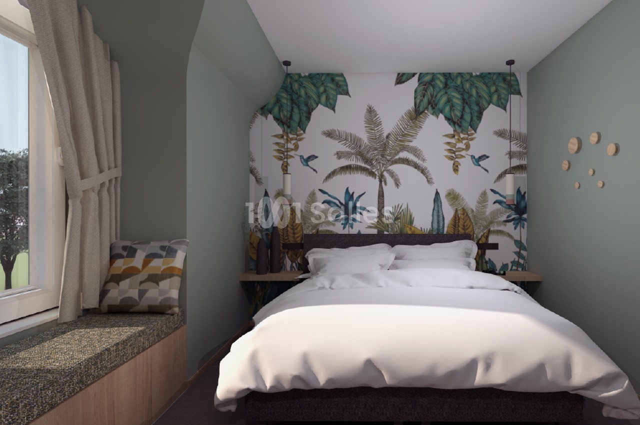 Chambre avec lit double, mur décoré d'un papier peint tropical, banquette près d'une fenêtre avec rideaux beiges.