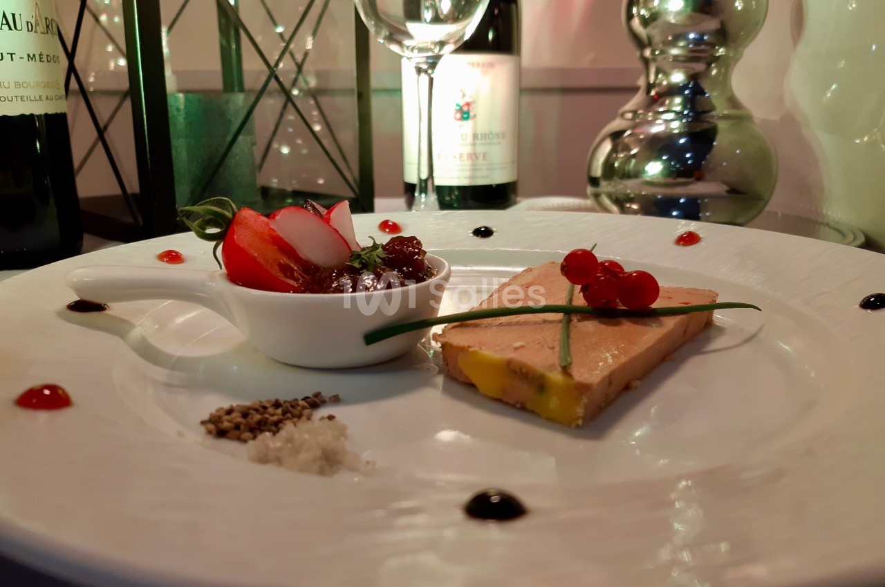 Assiette gastronomique avec foie gras, confiture, radis, groseilles, ciboulette et condiments, servie dans un décor élégant.