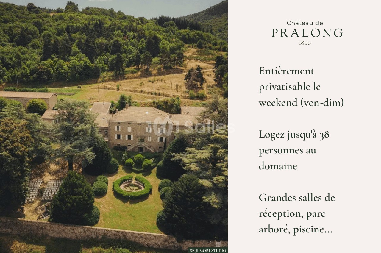 Vue aérienne d'un château entouré de jardins, d'arbres et de collines, avec une cour centrale aménagée.