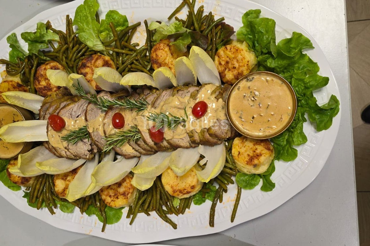 Plat de viande tranchée garni de sauce, haricots verts, endives, pommes de terre gratinées et salade verte.