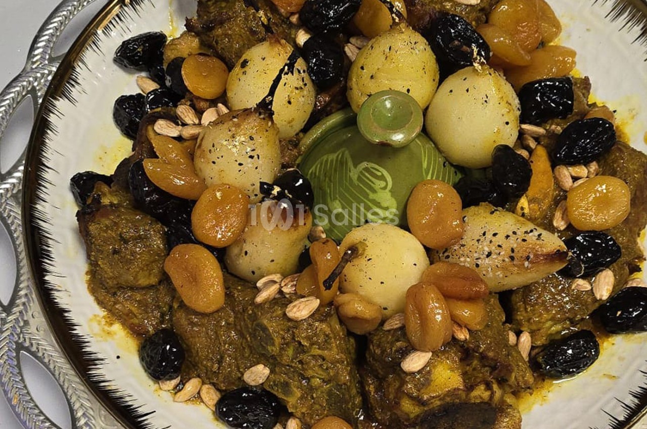 Plat marocain traditionnel composé d'agneau, de poires, d'abricots secs, d'amandes et d'olives noires, présenté dans un plat…