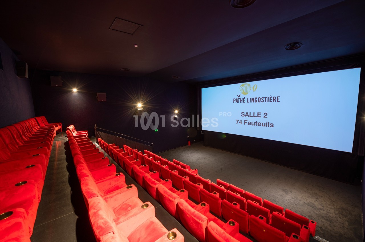 Salle de cinéma avec des rangées de fauteuils rouges et un écran affichant ’Pathé Lingostière, Salle 2, 74 fauteuils’.