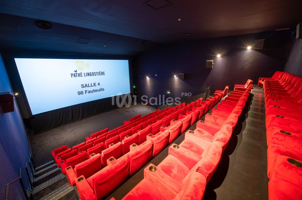 Salle de cinéma avec des rangées de fauteuils rouges vides et un écran affichant ’Salle 4, 98 fauteuils’.