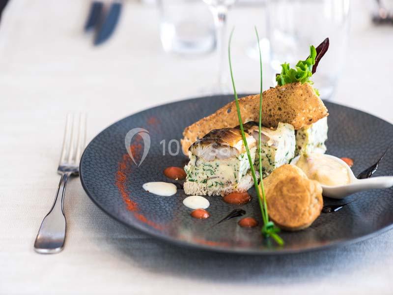 Assiette gastronomique avec poisson, mousse aux herbes, sauce, légumes, pain croustillant et présentation soignée.