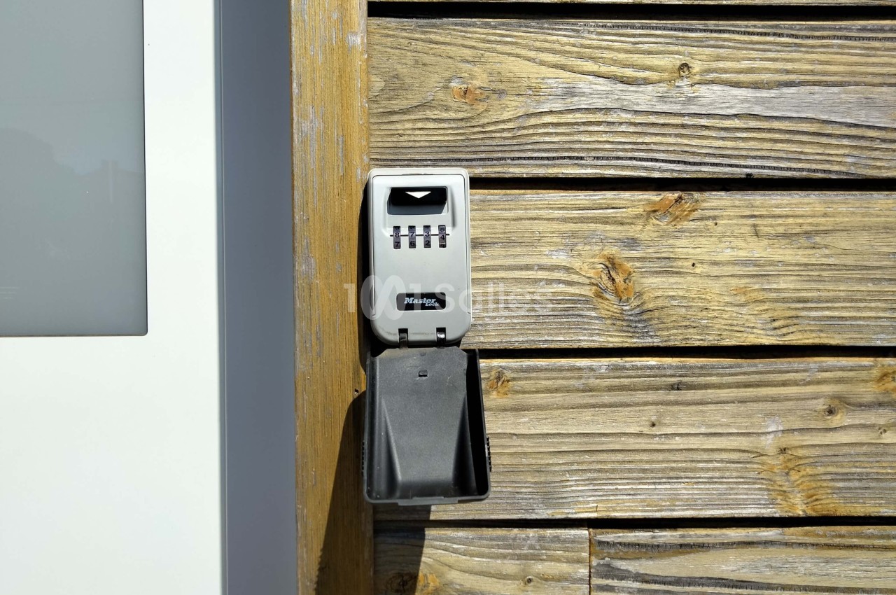 Boîtier à combinaison fixé sur un mur en bois, utilisé pour stocker des clés en toute sécurité.
