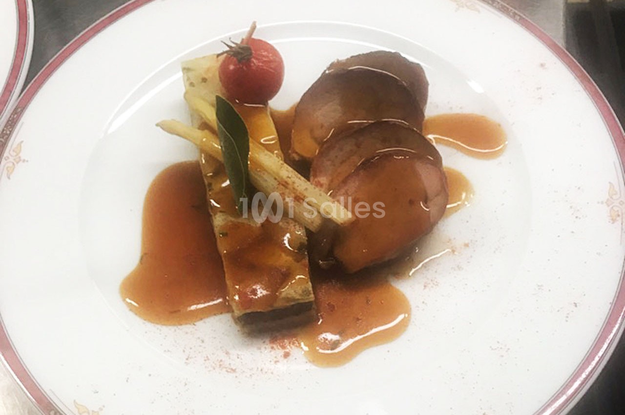 Assiette gastronomique avec viande en sauce, gratin de légumes, tomate cerise et décoration soignée.