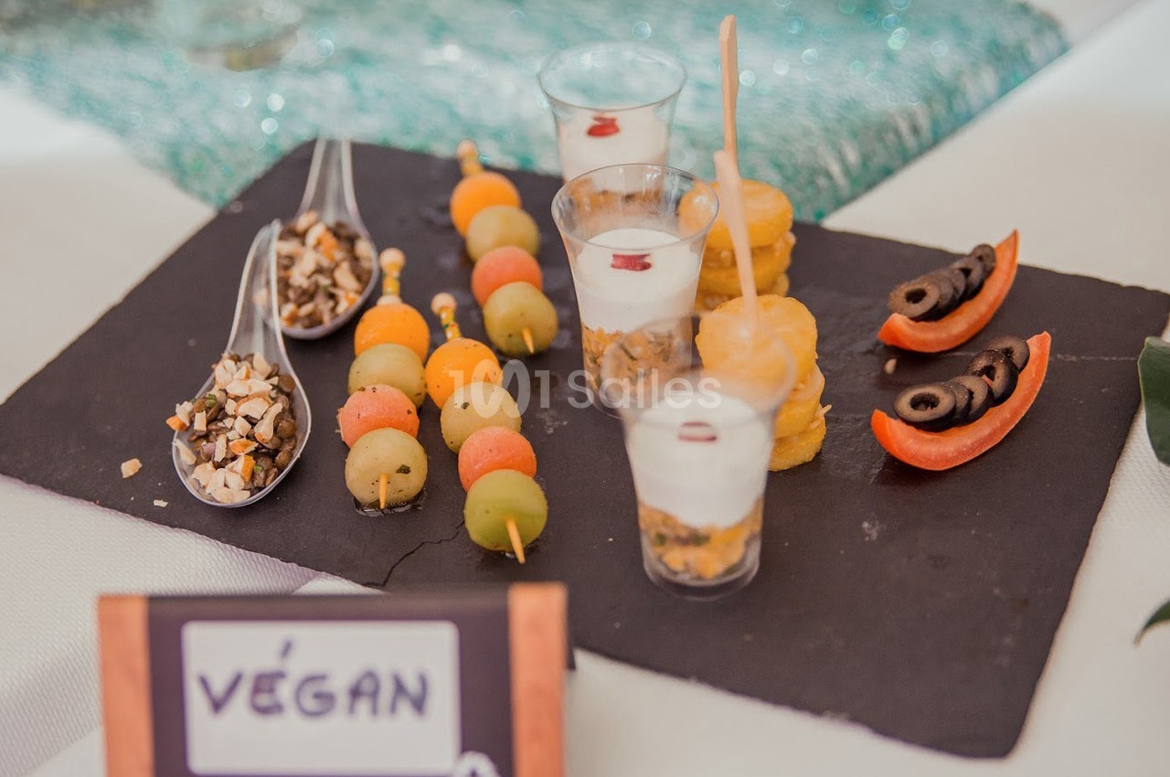 Plateau de dégustation avec verrines, brochettes de fruits, bouchées salées et garnitures végétaliennes.