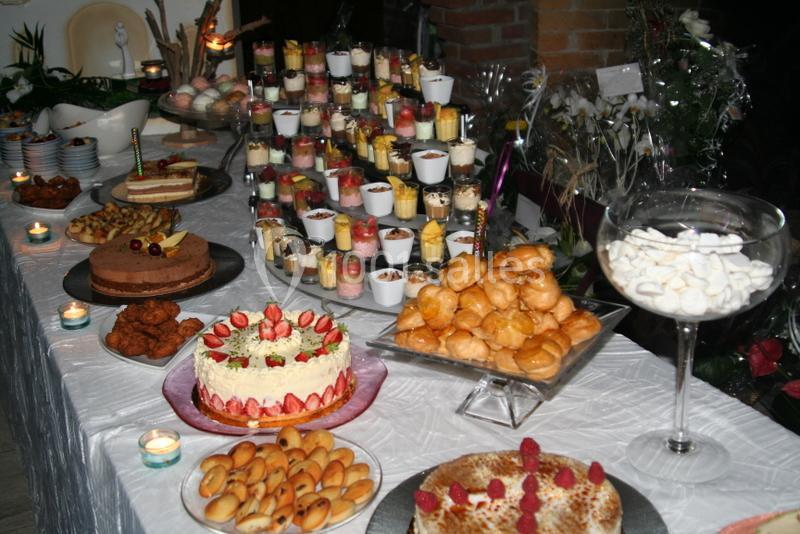 Buffet de desserts variés avec gâteaux, verrines, choux et autres pâtisseries disposés sur une table décorée.