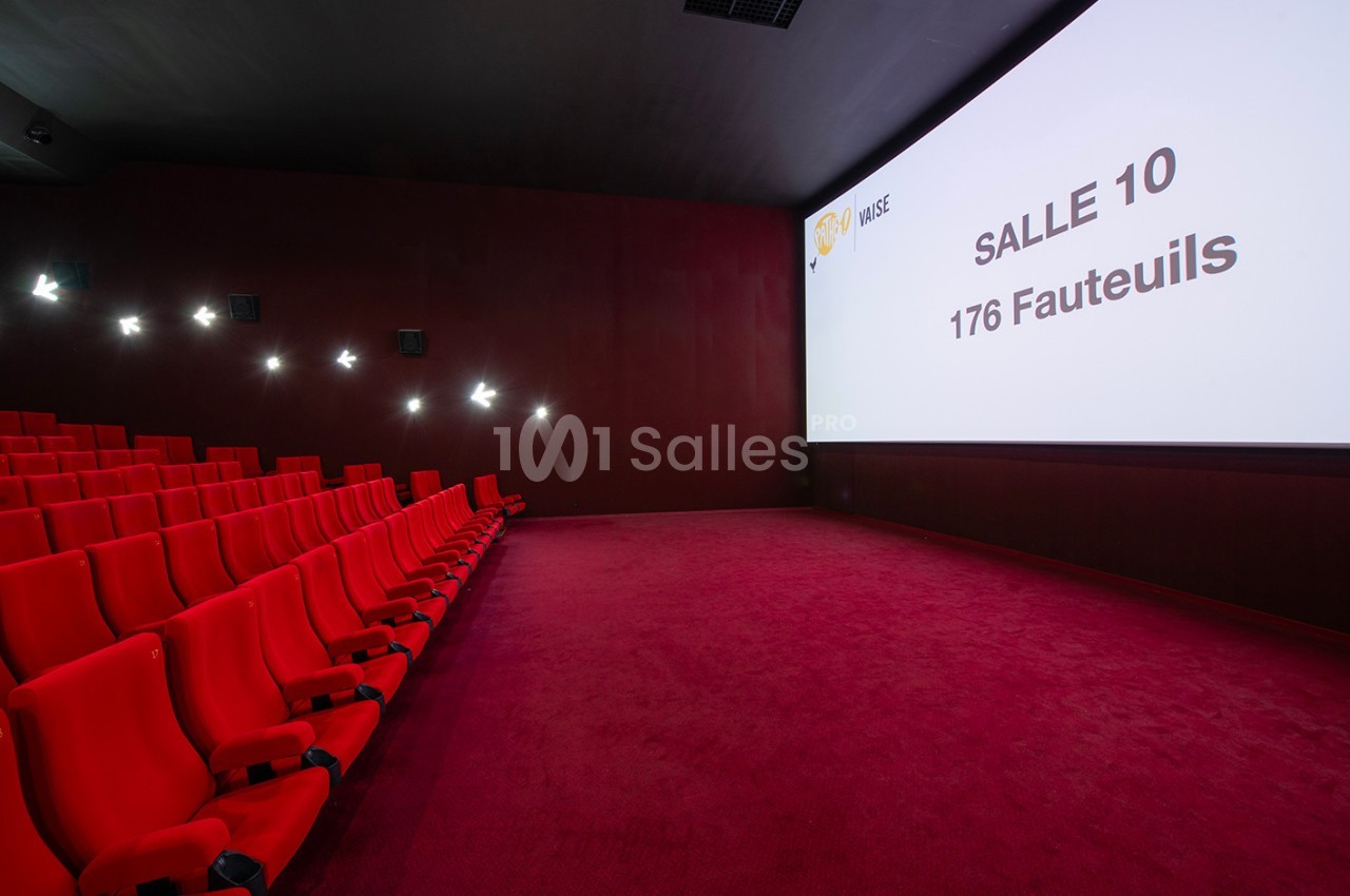 Salle de cinéma vide avec des sièges rouges alignés et un écran affichant ’Salle 10, 176 fauteuils’.
