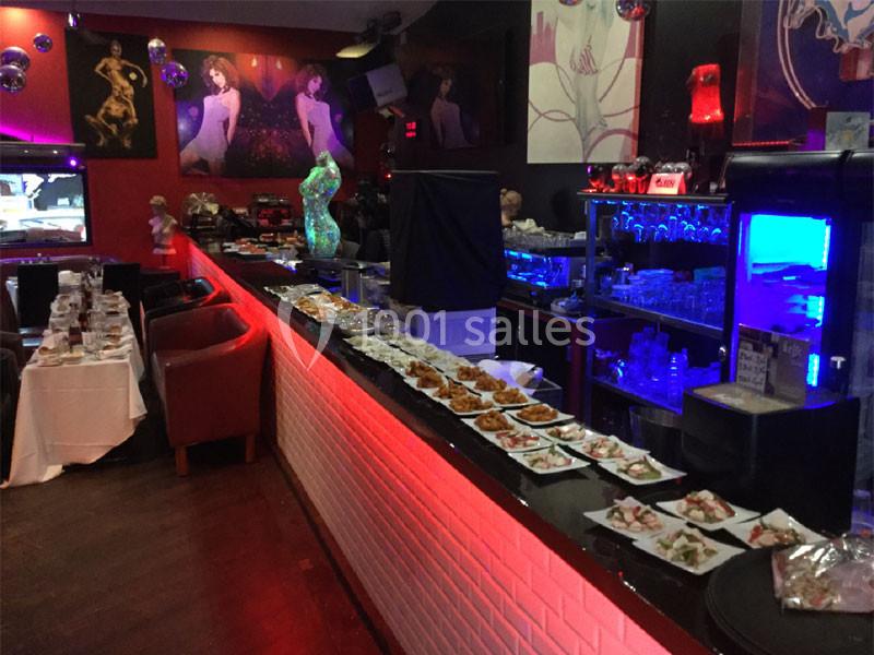 Buffet de plats variés disposés sur un comptoir éclairé, dans un restaurant à l'ambiance colorée et artistique.
