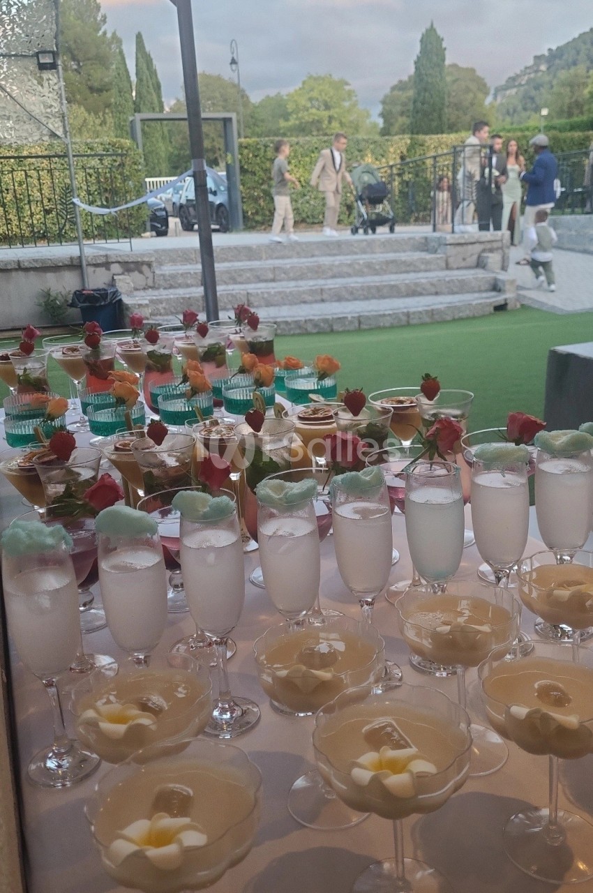 Desserts variés présentés sur une table, avec une vue sur un jardin et des passants en arrière-plan.