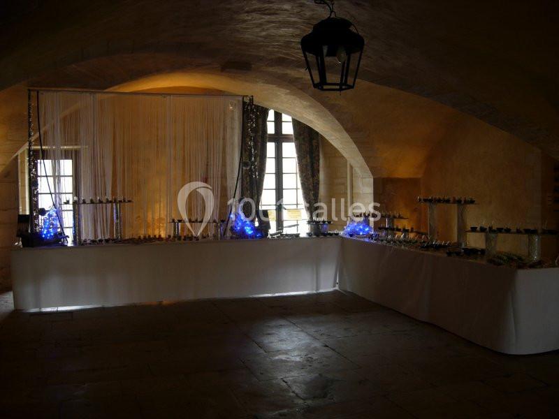 Table de buffet décorée avec des lumières bleues dans une salle voûtée éclairée par des fenêtres.