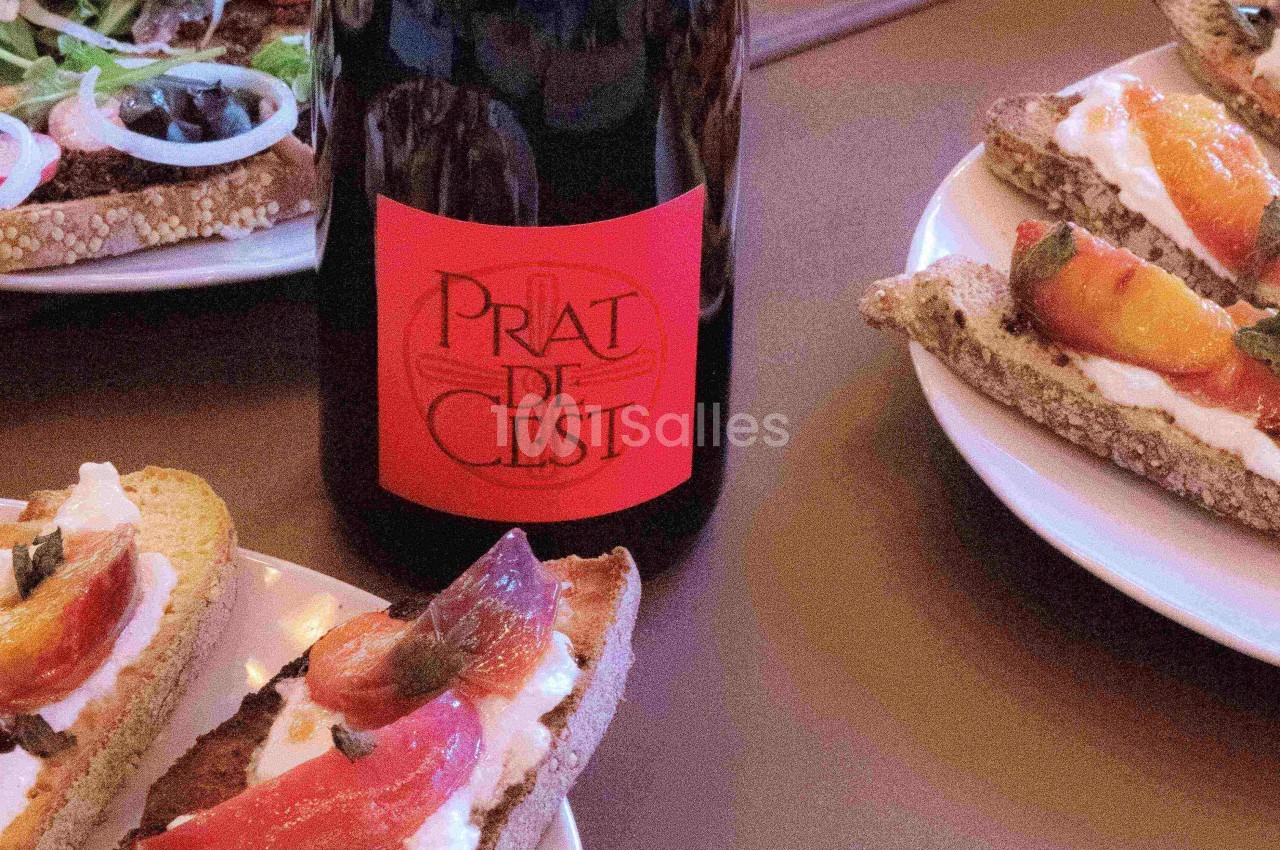 Bouteille de vin rouge avec étiquette rouge entourée d'assiettes de tartines garnies de fromage et de légumes.