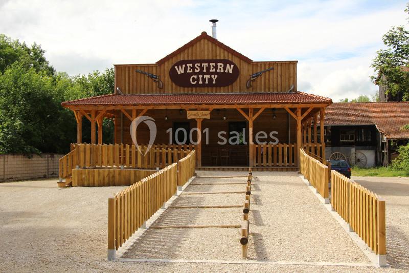 Façade en bois d'un bâtiment de style western avec une enseigne ’Western City’ et une allée clôturée.