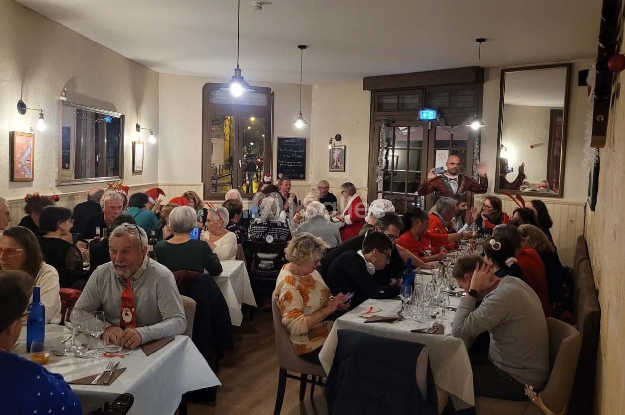 Des personnes d'âges variés dînent dans un restaurant chaleureux, décoré pour une ambiance conviviale.