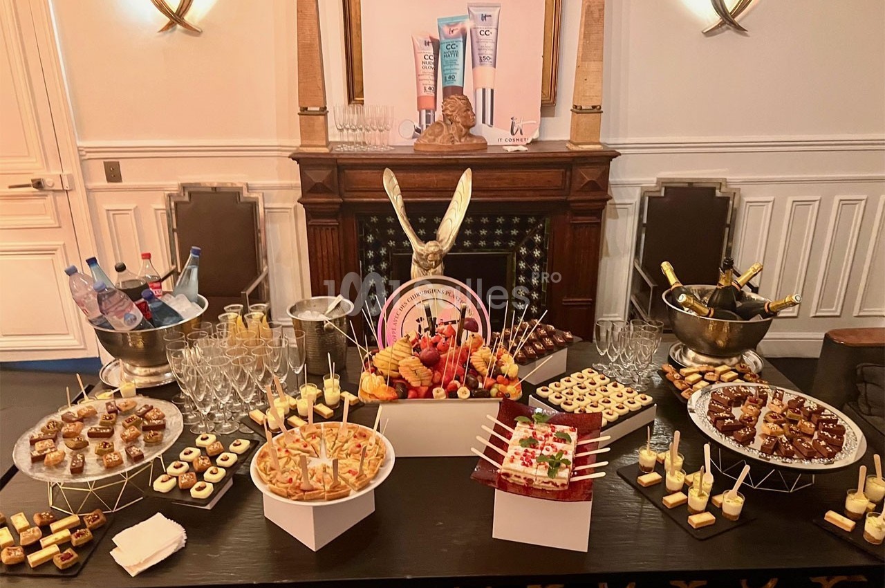 Buffet de desserts variés avec verrines, pâtisseries et boissons, présenté sur une table dans une salle élégante.