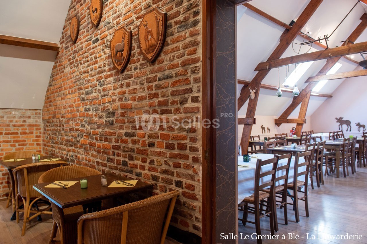 Salle de restaurant rustique avec murs en briques, poutres apparentes et mobilier en bois.