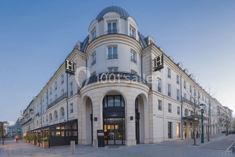 Façade d'un hôtel de style classique avec enseigne ’L'Élysée’, situé dans une rue calme et bordée de lampadaires.