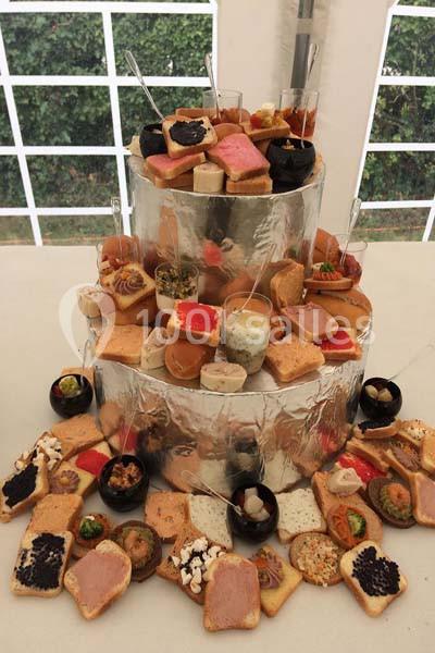 Plateau à plusieurs niveaux garni de toasts variés, verrines et amuse-bouches, présenté sur une table blanche.