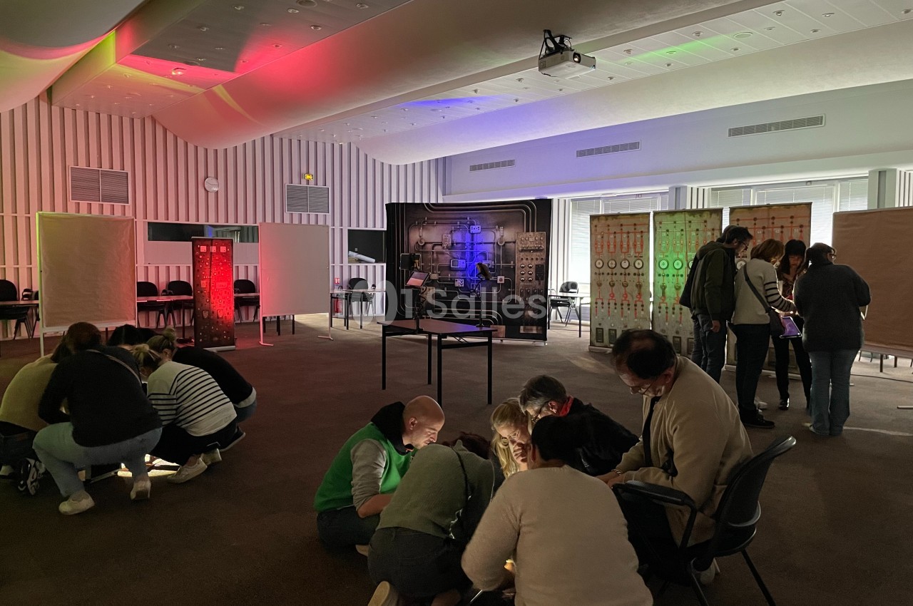 Des personnes participent à une activité collaborative dans une salle éclairée par des lumières colorées.