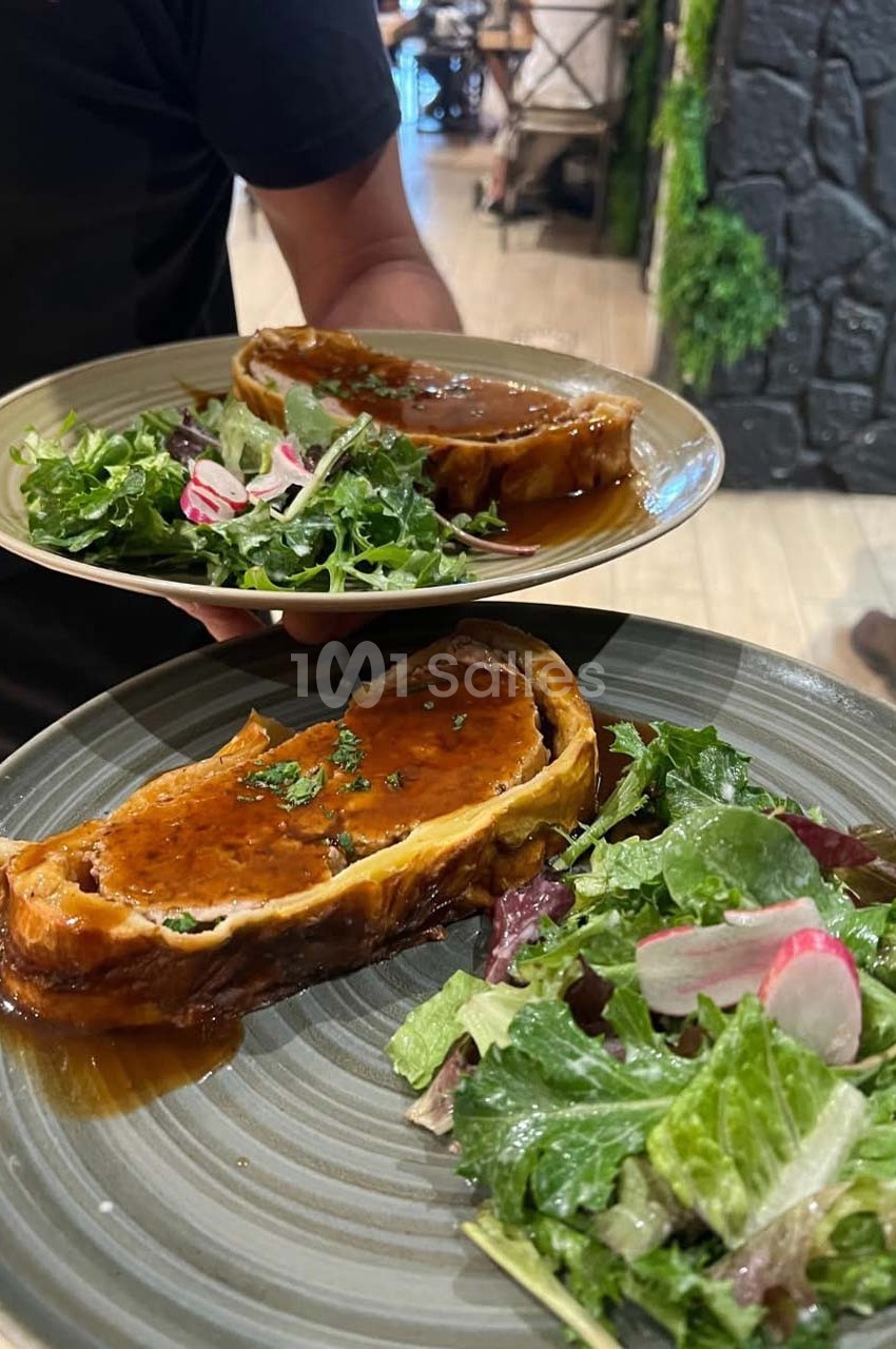Deux assiettes contenant un feuilleté en sauce accompagné d'une salade verte avec radis tranchés.