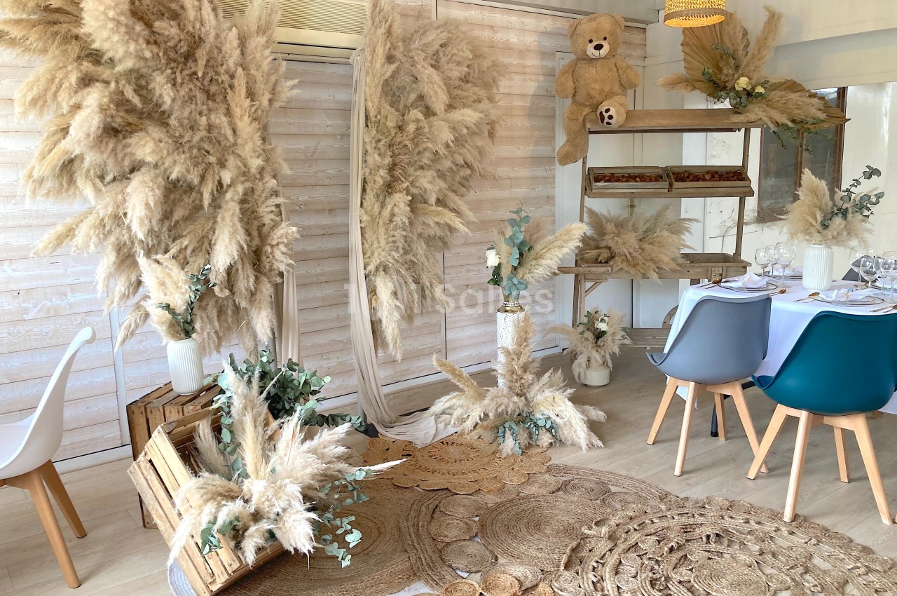 Décoration intérieure avec pampas, tapis en fibres naturelles, chaises modernes et table dressée dans un style bohème.