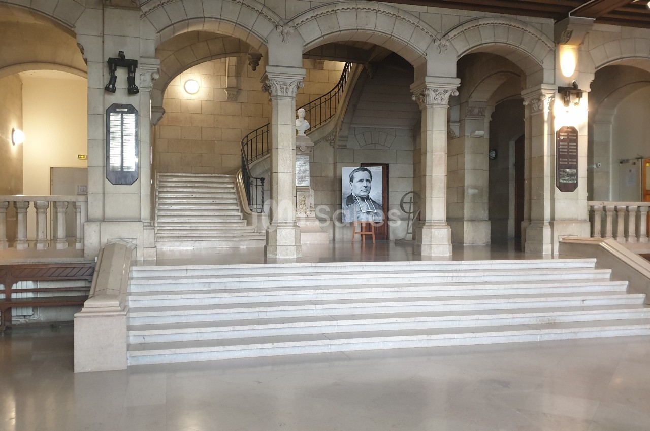 Escalier en pierre dans un bâtiment historique avec une photo en noir et blanc exposée sur un chevalet.