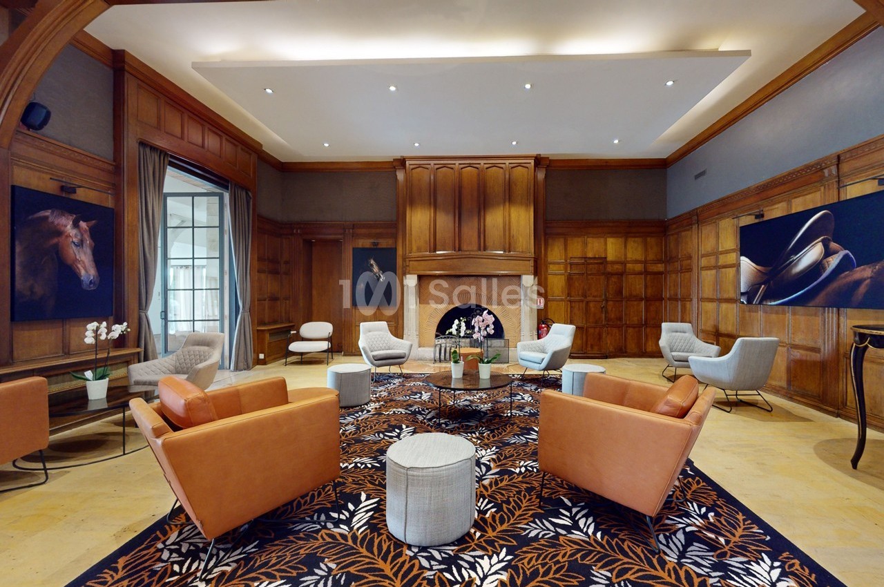 Salle élégante avec fauteuils en cuir, tapis à motifs floraux, cheminée centrale et œuvres d'art sur les murs en bois.