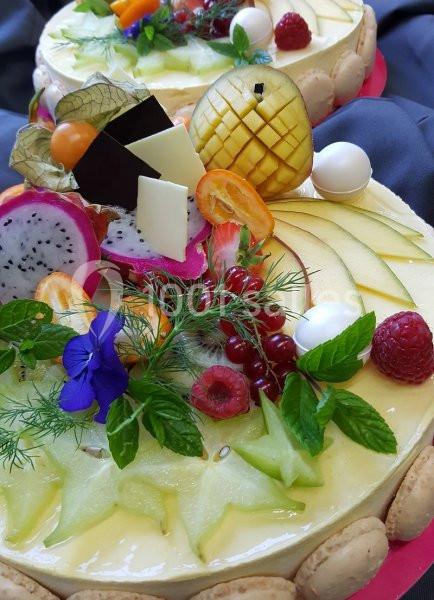 Tarte garnie de fruits frais variés, dont mangue, fruit du dragon, groseilles et fleurs comestibles.