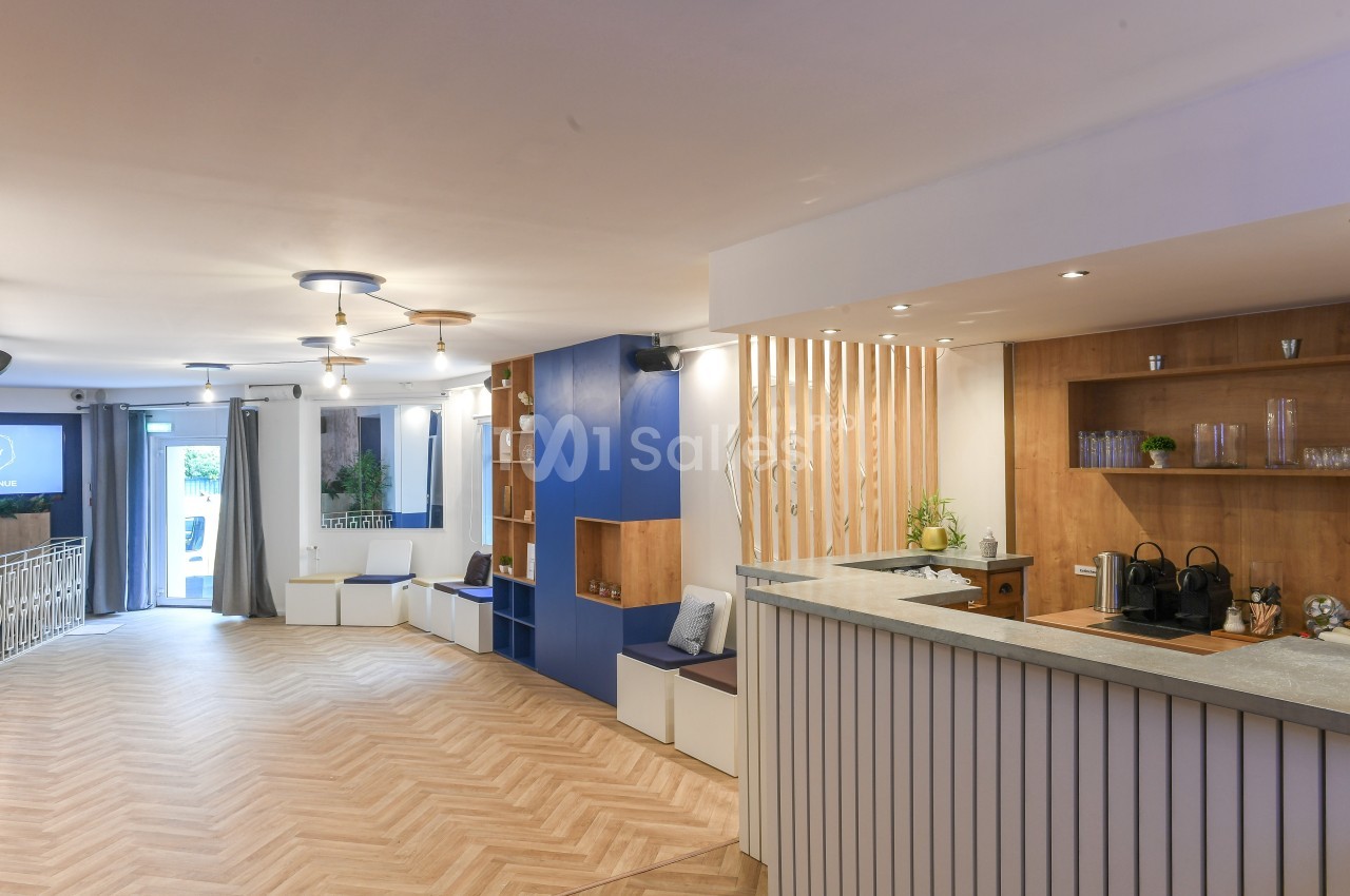 Espace intérieur lumineux avec comptoir en bois, assises intégrées, parquet clair et décorations modernes.