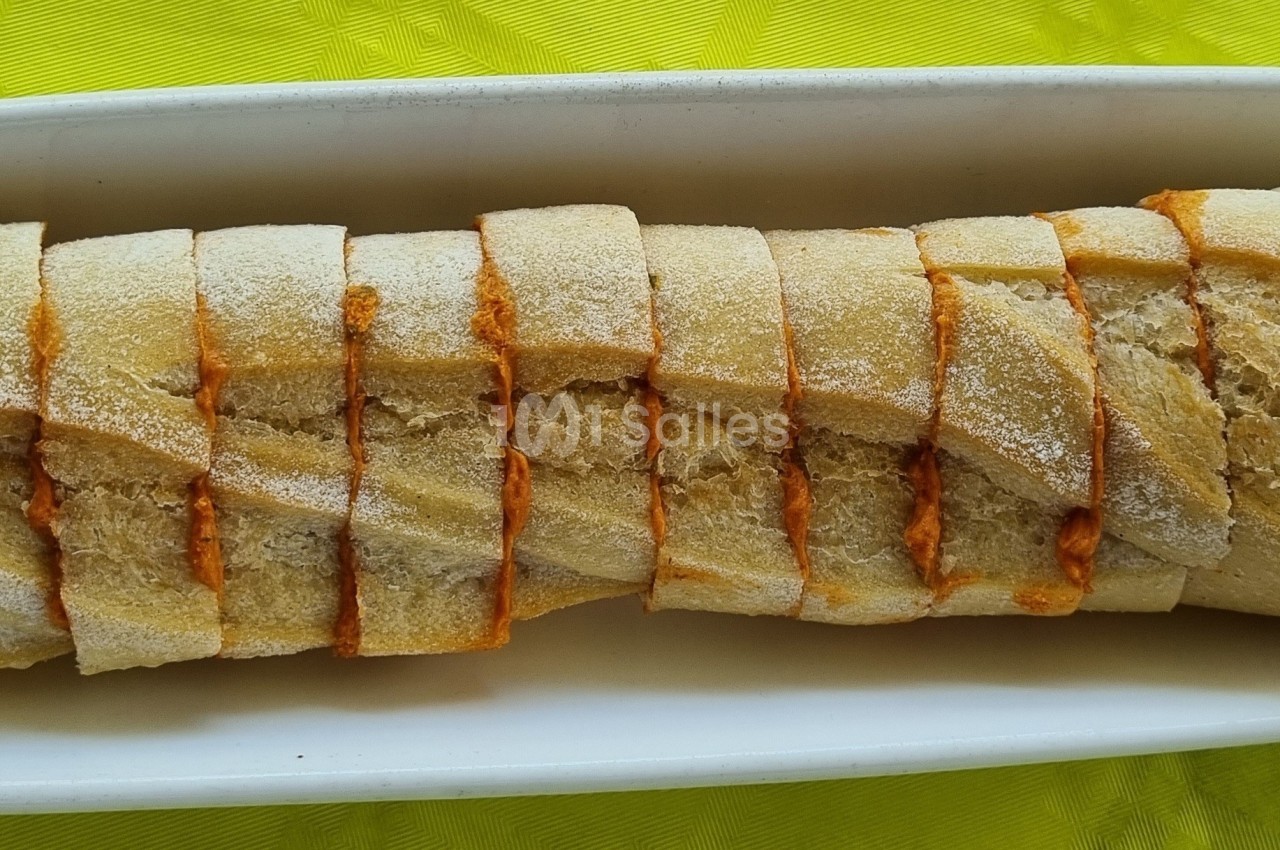 Tranches de pain disposées en ligne dans un plat blanc sur une nappe jaune.