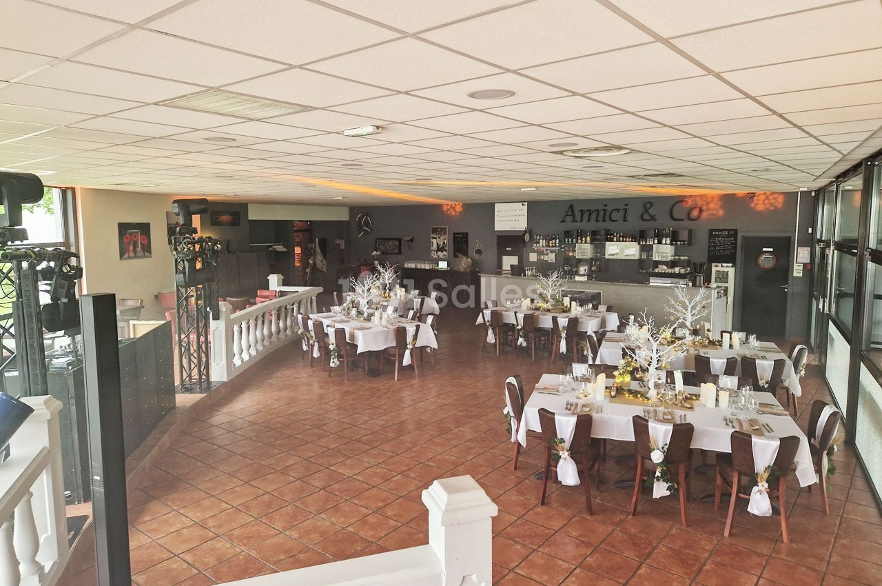 Salle de restaurant lumineuse avec tables dressées pour un événement, décorations élégantes et ambiance chaleureuse.