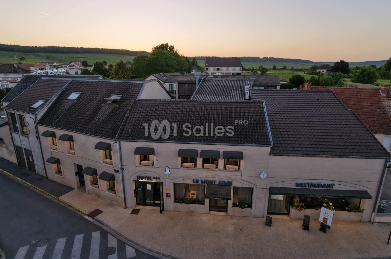 Façade d'un bâtiment en pierre avec un restaurant, vue au crépuscule dans un village rural.