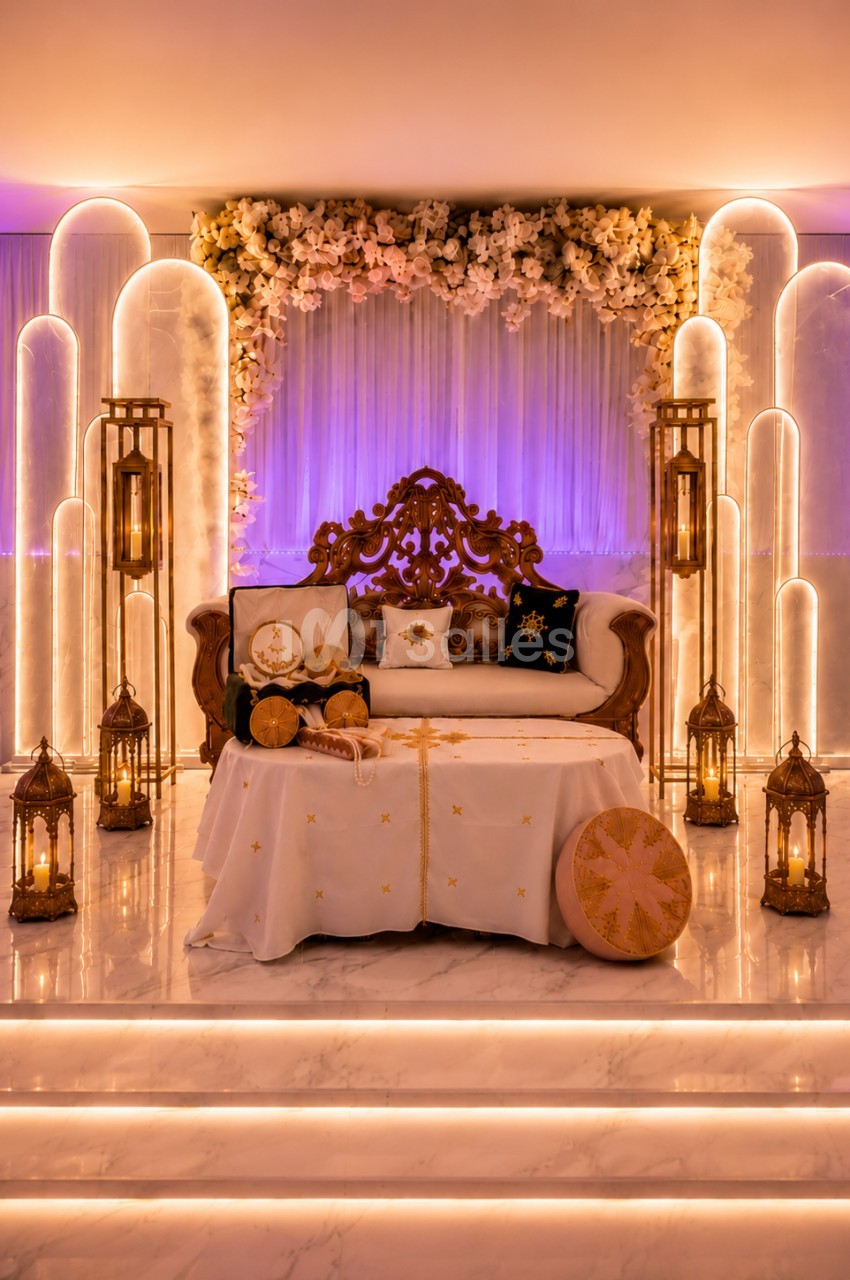 Décor lumineux avec canapé orné, table basse décorée et lanternes dorées, sur fond de fleurs et éclairages doux.
