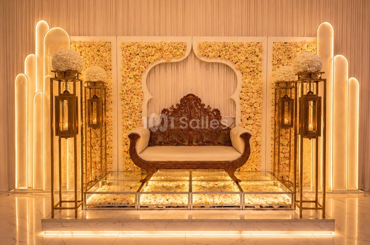 Décor élégant avec un canapé sculpté, fond de fleurs pastel et lanternes dorées sur un sol en marbre.