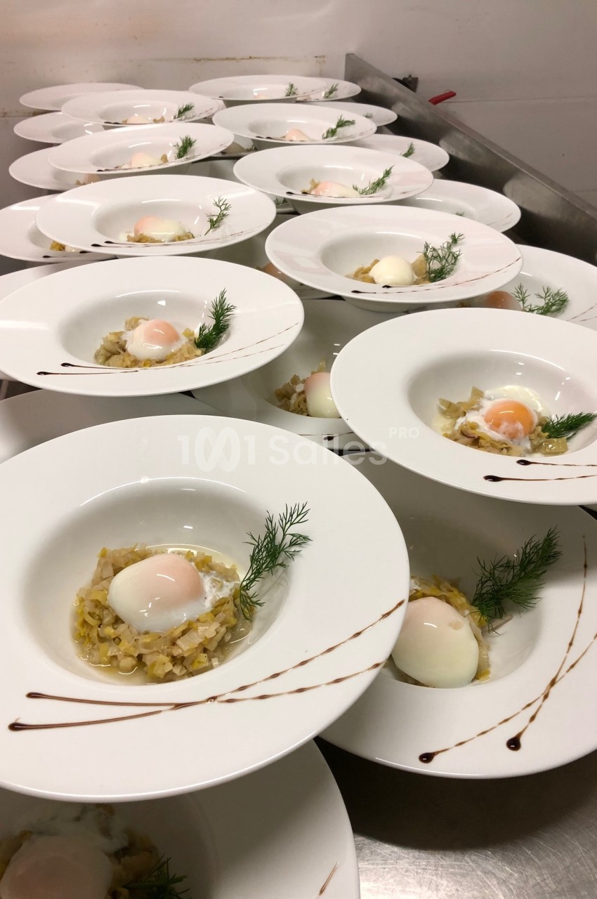 Assiettes dressées avec des œufs pochés sur un lit de légumes, décorées de brins d'aneth et de traits de sauce.
