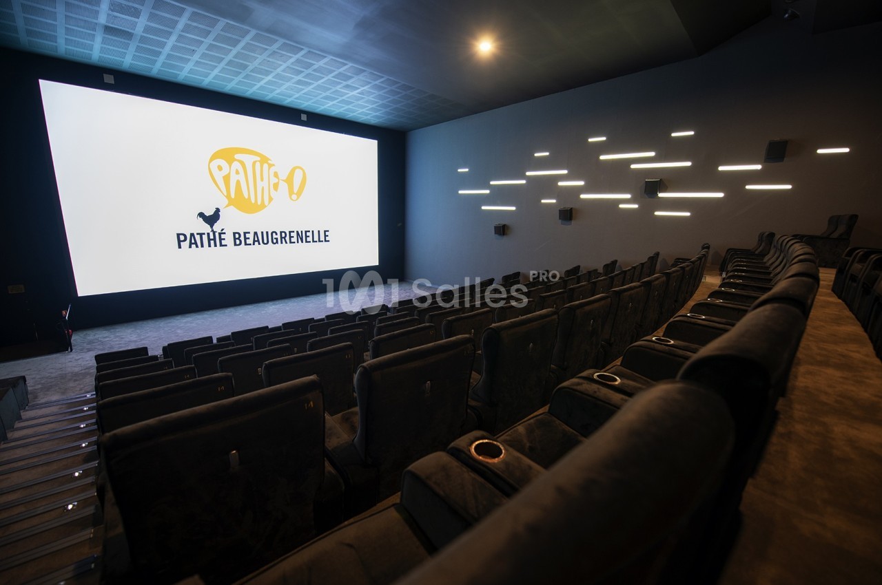 Salle de cinéma moderne avec sièges en rangées, grand écran allumé affichant ’Pathé Beaugrenelle’ et éclairage mural.