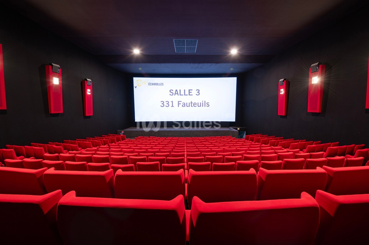 Salle de cinéma vide avec des rangées de fauteuils rouges et un écran affichant ’Salle 3 - 331 fauteuils’.