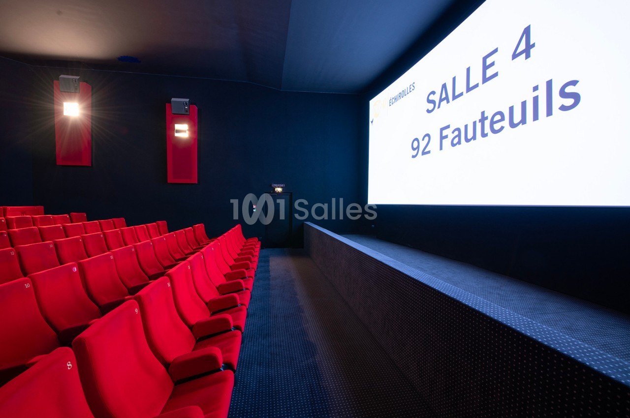 Salle de cinéma moderne avec rangées de fauteuils rouges et écran affichant ’Salle 4 - 92 fauteuils’.