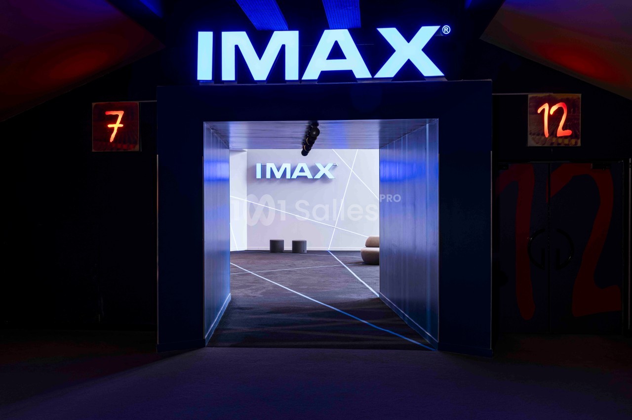 Entrée d'une salle IMAX avec signalétique lumineuse, murs sombres et numéros de salles 7 et 12 visibles.