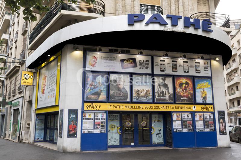 Façade d'un cinéma Pathé avec affiches de films et panneaux d'information visibles sur les vitrines.