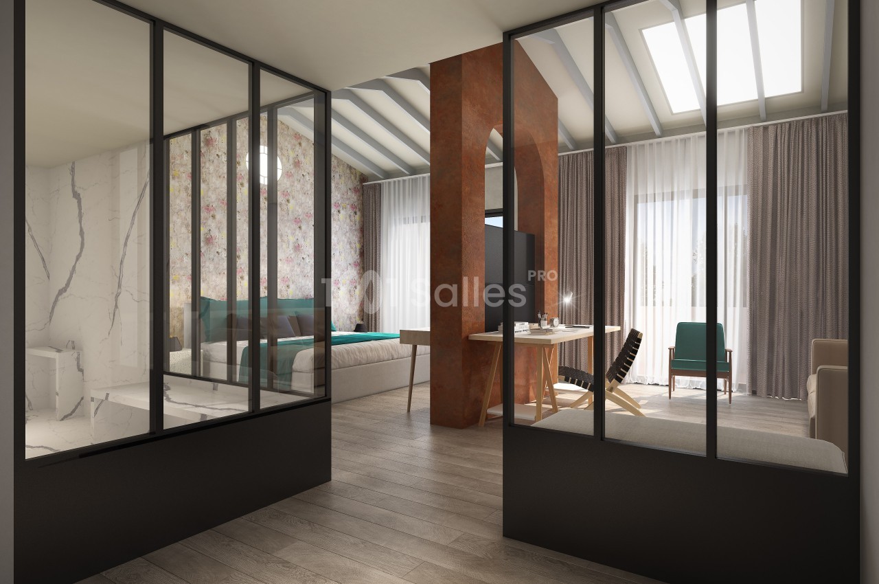 Vue intérieure d'un espace moderne avec cloison vitrée, chambre, salon et lumière naturelle entrant par des fenêtres.